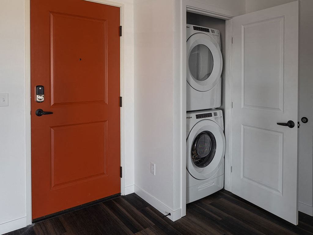 a door is open to a laundry room with a washer and dryer at The Landing at 1001 NP, Fargo, North Dakota 58102