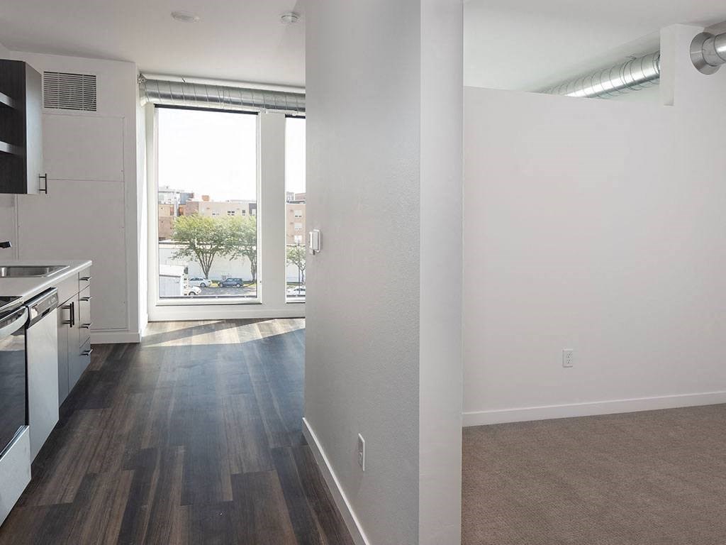 an empty kitchen and living room with a large window at The Landing at 1001 NP, Fargo, ND, 58102