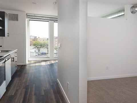 an empty kitchen and living room with a large window at The Landing at 1001 NP, Fargo, ND, 58102