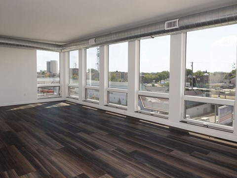 a living room with a large window and hardwood floors at The Landing at 1001 NP, Fargo, ND 58102