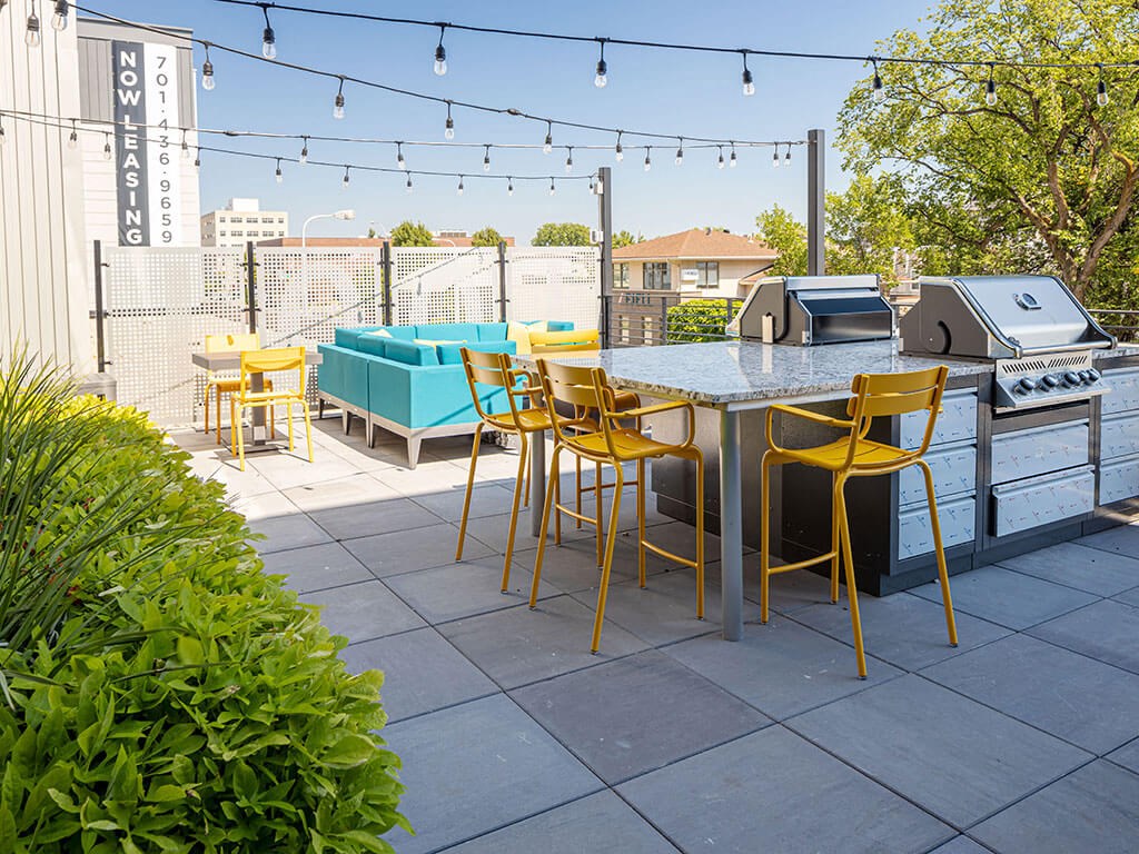 a patio with a table and chairs and a grill at The Landing at 1001 NP, Fargo, ND 58102