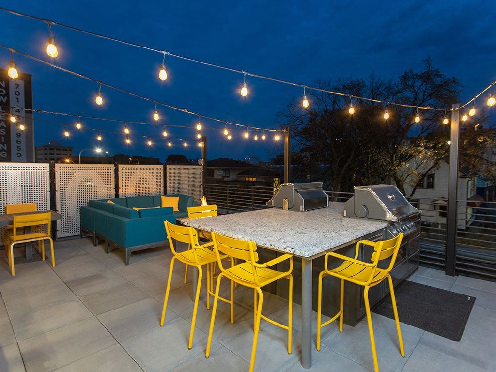 a rooftop deck with a dining table and yellow chairs at The Landing at 1001 NP, Fargo, ND 58102