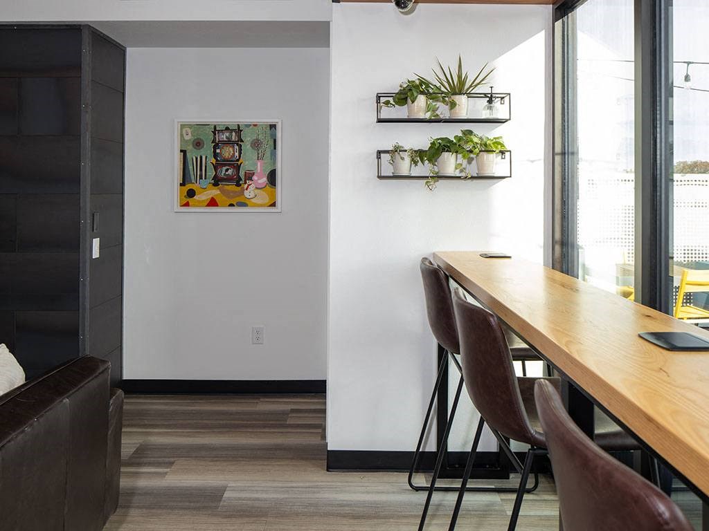 a long wooden table sitting next to a window at The Landing at 1001 NP, Fargo, North Dakota, 58102