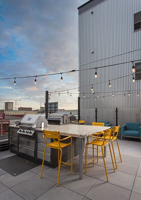 a patio with a table and chairs and a grill at The Landing at 1001 NP, Fargo, ND, 58102