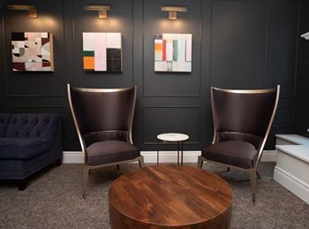 Two chairs and a table are in a room with artwork on the wall at RoCo Apartments, Fargo, ND 58102