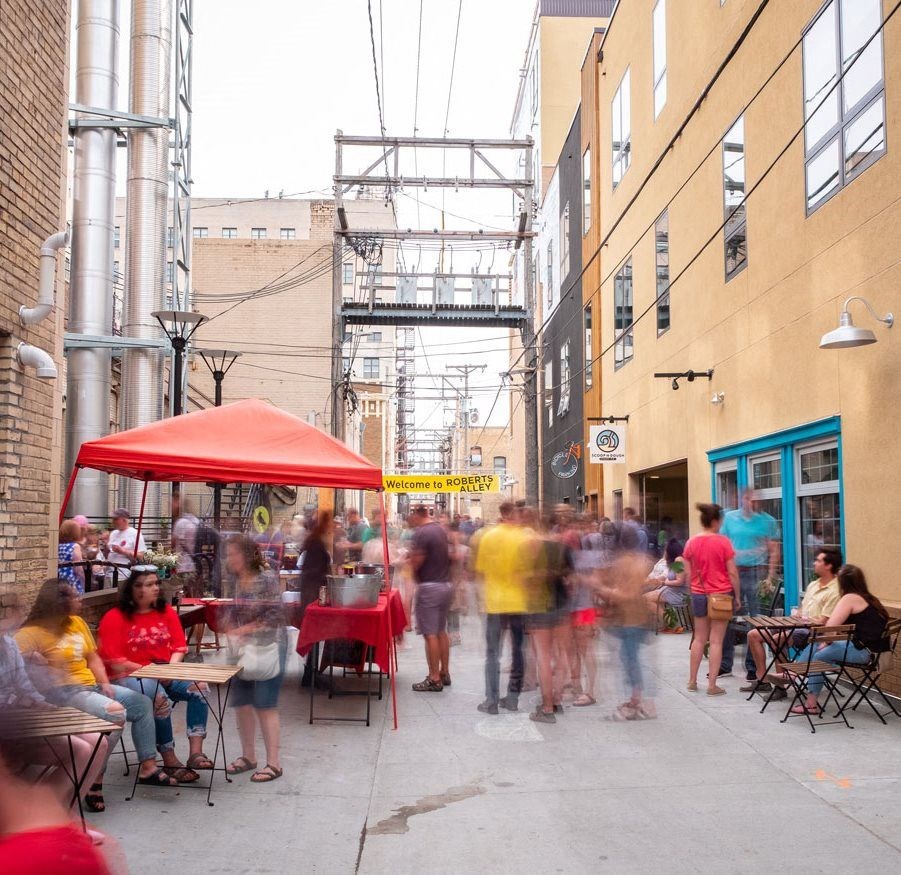 A city street filled with people and a red tent  at RoCo Apartments, Fargo, North Dakota, 58102
