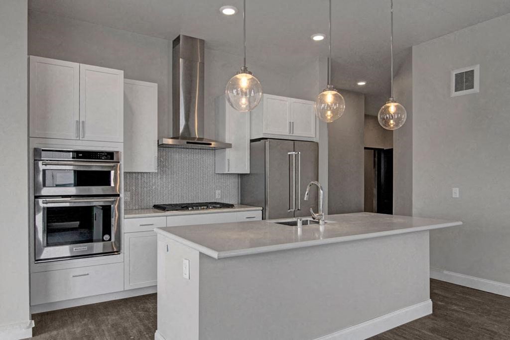 a kitchen with white cabinets and stainless steel appliances