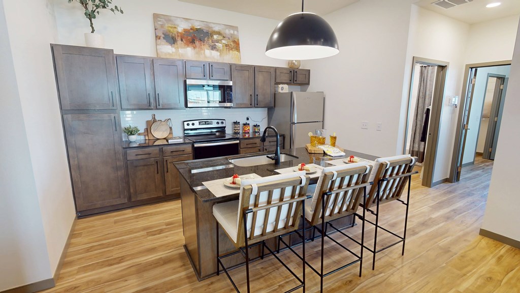A kitchen with a table and chairs in front of a refrigerator.
