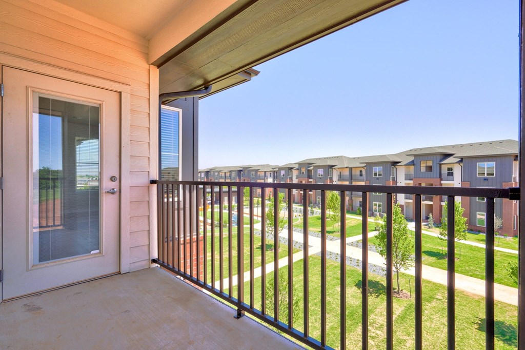 the view from the balcony of an apartment building with a glass door and railings