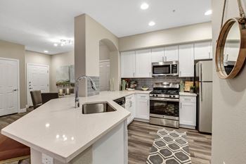 an open kitchen with white cabinets and stainless steel appliances