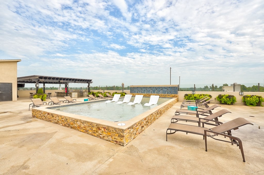 a rooftop hot tub with lounge chairs and a gazebo