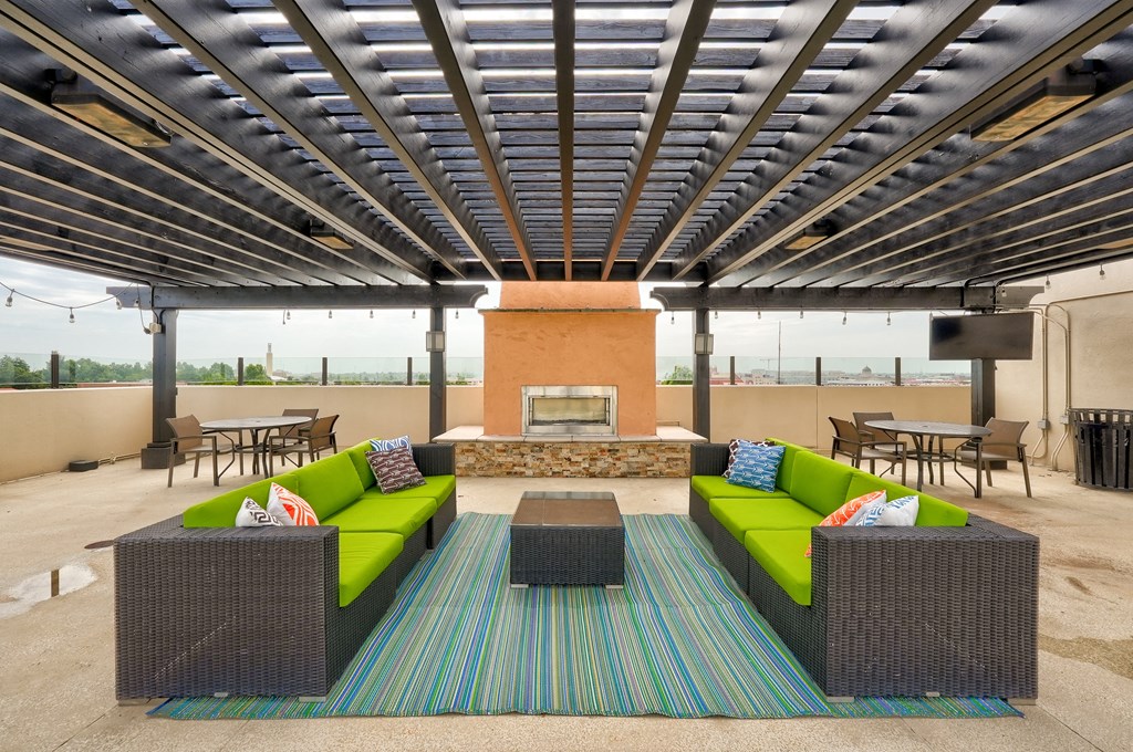 a patio with couches and tables and a fireplace