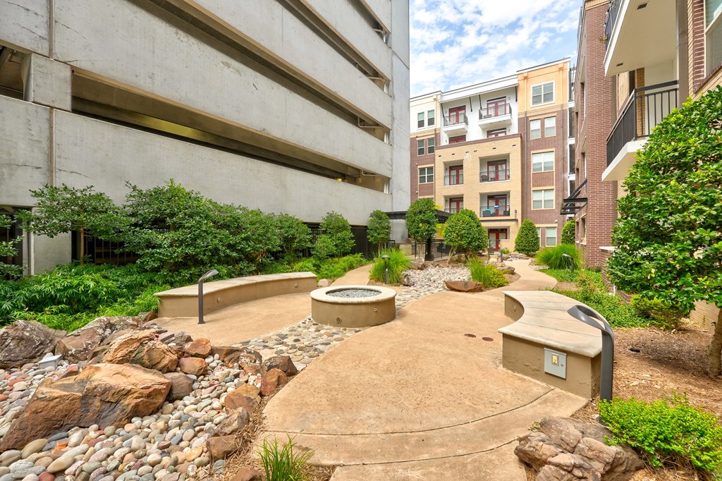 an outdoor area with benches and rocks and plants