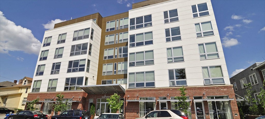 A modern multi-story building with a mix of white and brown facades.