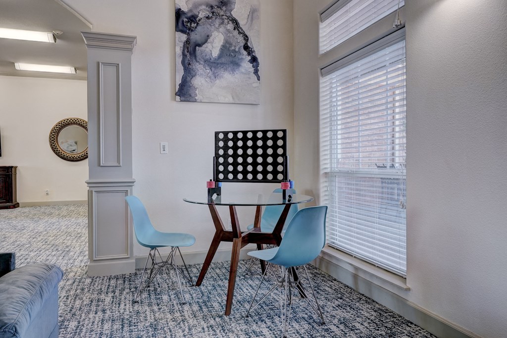 a dining area with a table and chairs and two windows