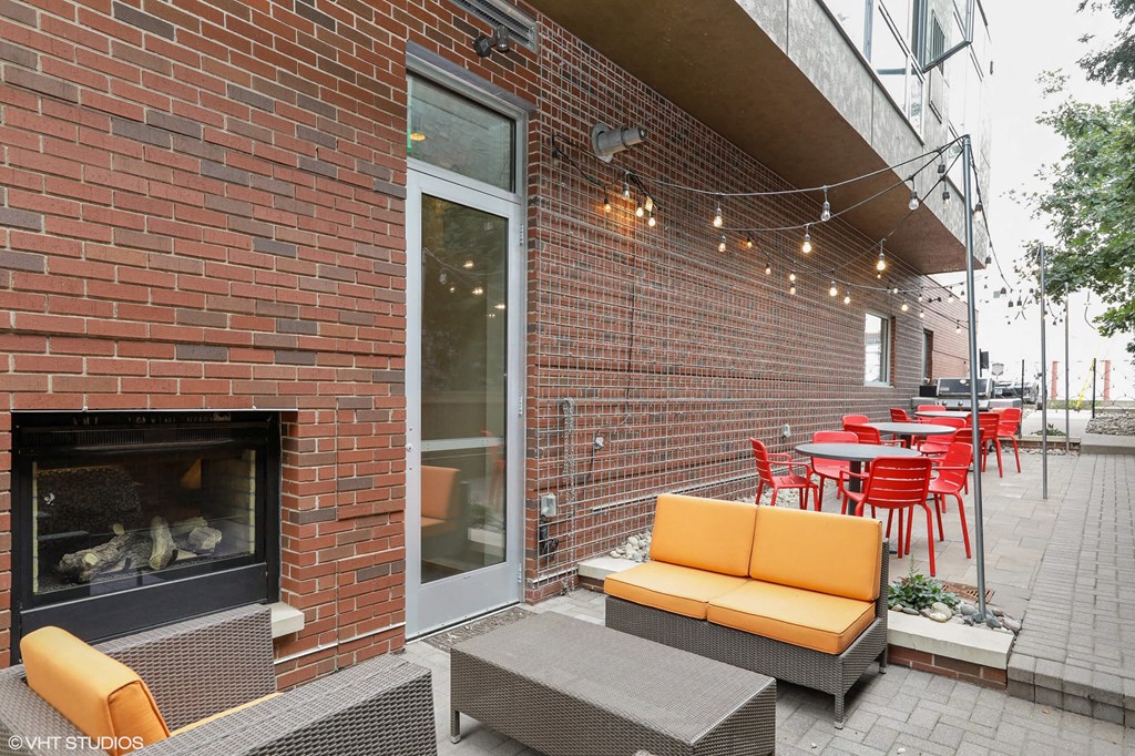 a patio with tables and chairs and a fireplace
