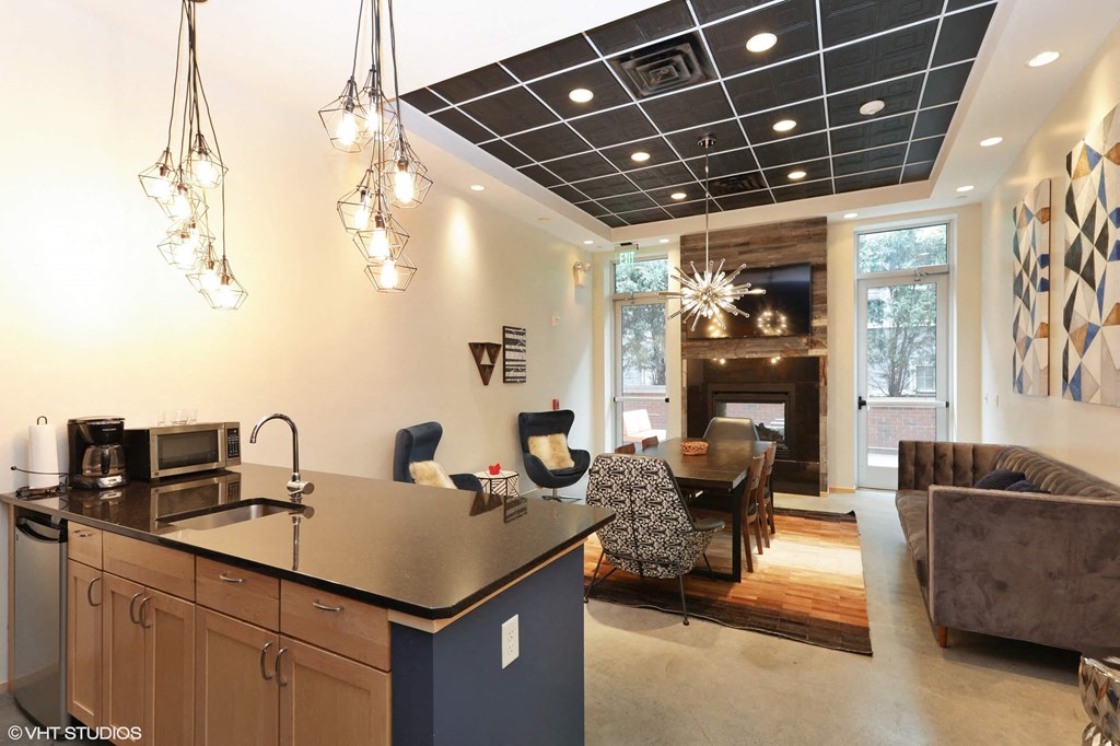 A modern kitchen with a black countertop and a black and white checkered wall art.
