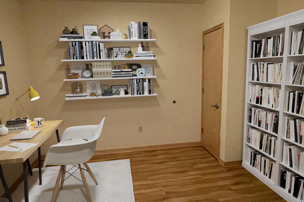 A room with a desk, chair, and bookshelves filled with books.