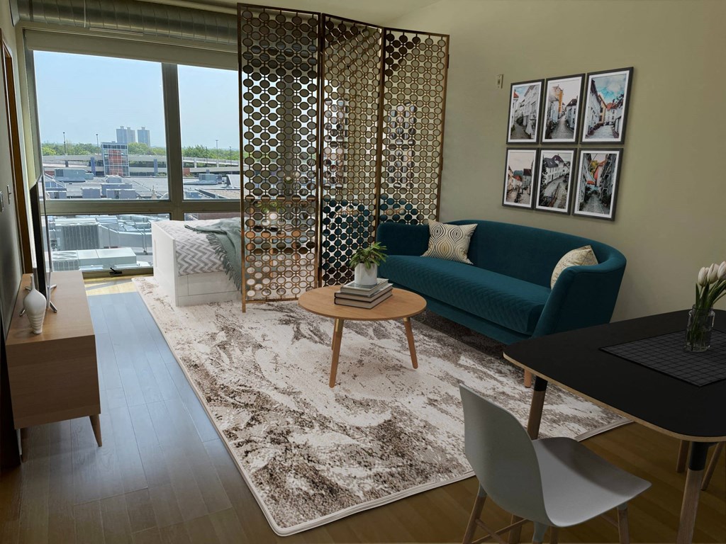 A living room with a blue couch and a table with a vase of flowers on it.