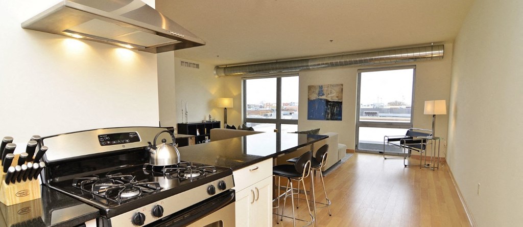 a kitchen and living room with a stove and a counter