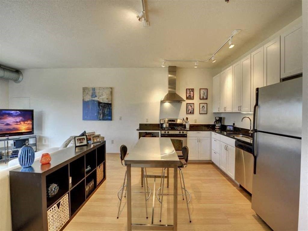 A modern kitchen with a table and chairs in the middle.