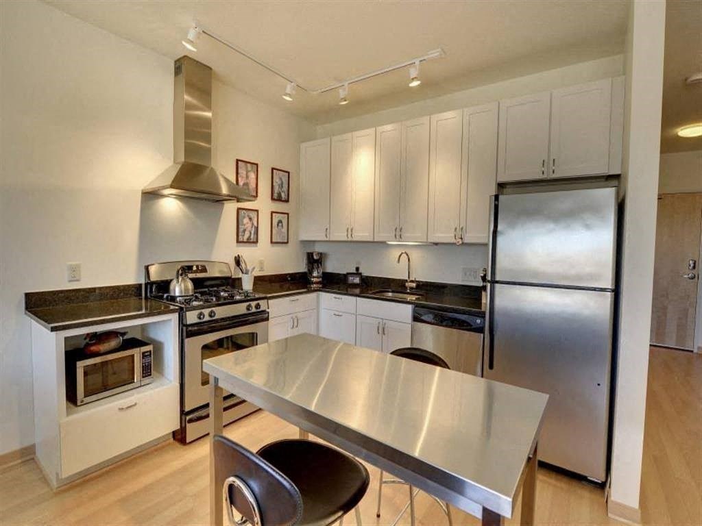 a kitchen with stainless steel appliances and a table