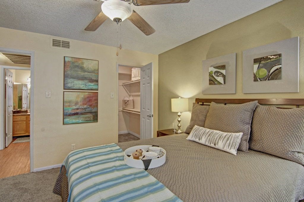 a bedroom with a bed and a ceiling fan