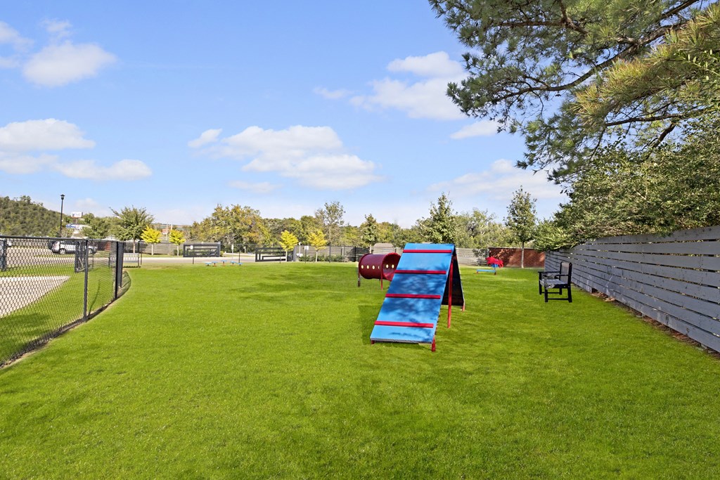 a playground with a blue bench in the middle of a field