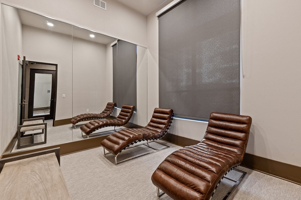 a private screening room with leather chairs in front of a mirror