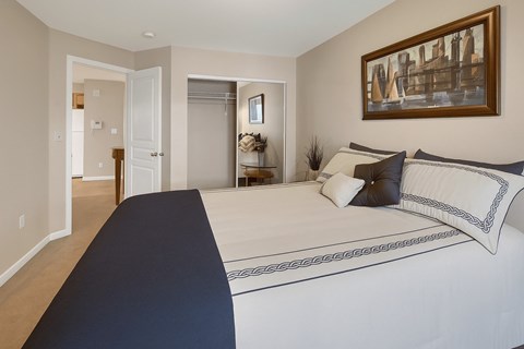 A bedroom with a large bed and a painting on the wall.
