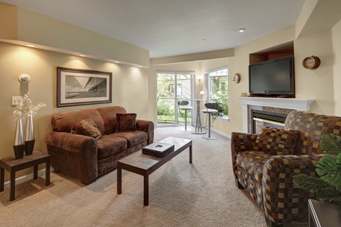 A living room with a brown couch, a coffee table, and a fireplace.