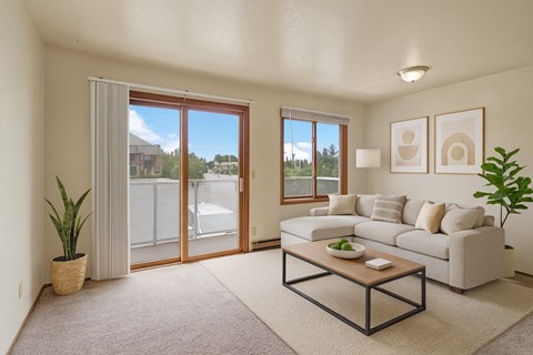 A living room with a couch, coffee table, and sliding glass doors.