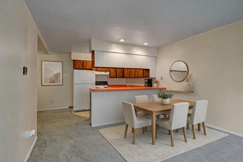 A kitchen with a dining table and chairs.