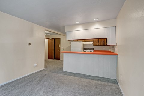 A room with a white reception desk and a grey carpet.