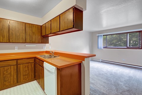 A kitchen with wooden cabinets and a white dishwasher.