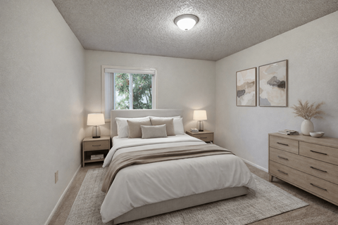 A bedroom with a large bed and two nightstands with lamps.