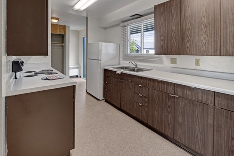 A kitchen with brown cabinets and a white counter top.