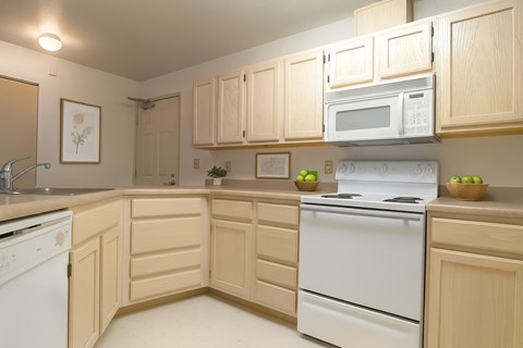 A kitchen with wooden cabinets and white appliances.