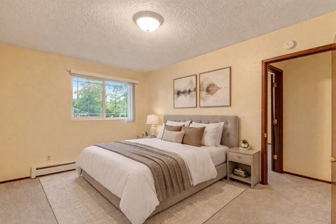 A bedroom with a large bed and a window.