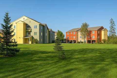 A grassy field with two buildings in the background.