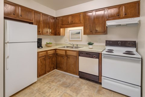 A kitchen with brown cabinets and a white refrigerator.