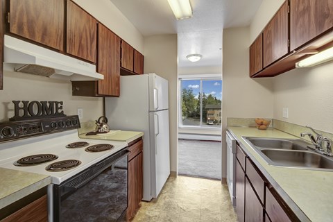 Galley kitchen with double sink and tile flooring at Castle Homes Apartments, Alaska, 99503
