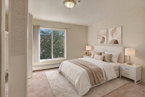 Bright bedroom with upholstered bed and neutral tones at Castle Homes Apartments, Anchorage, AK 99503
