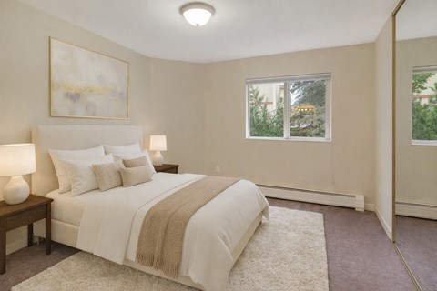 A bedroom with a large bed and a painting on the wall.