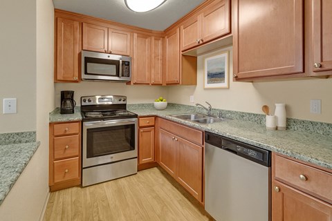 A kitchen with wooden cabinets and granite countertops.