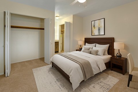 A bedroom with a large bed and a chair.
