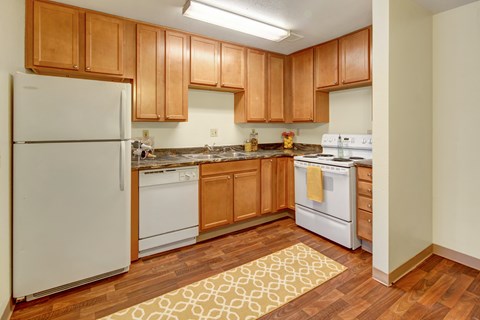 A kitchen with wooden cabinets and white appliances.