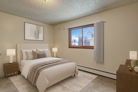 A bedroom with a large bed and a window with a view of trees outside.