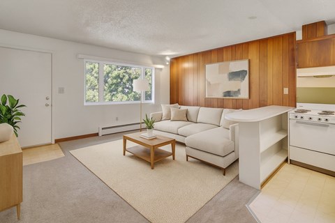 A living room with a couch, coffee table, and a painting on the wall.