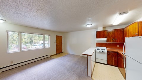 A kitchen with white appliances and wooden cabinets.